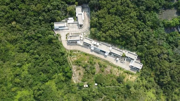 Aerial view of Dhamma Mutta buildings surrounded by green hills.