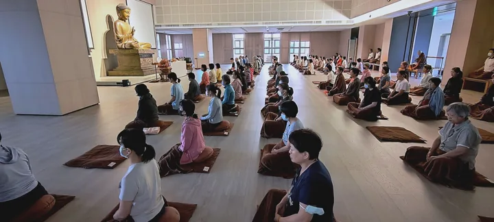 Participants seated in rows in Yunji Temple's bright meditation hall.