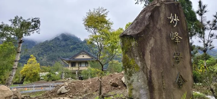 Miaofeng Retreat House beside an engraved stone bearing the name 妙峰學舍.