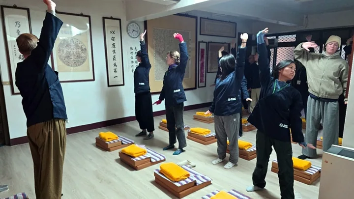 Farming Zen retreat participants stretch together in the practice hall.