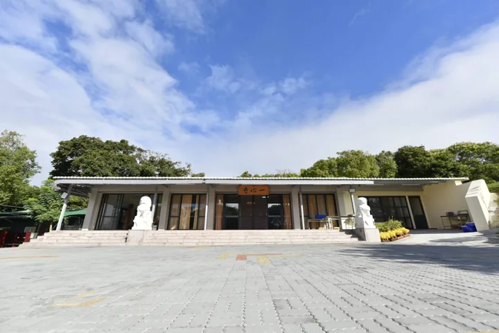 Low modern Yixin Temple meditation building under a blue sky.