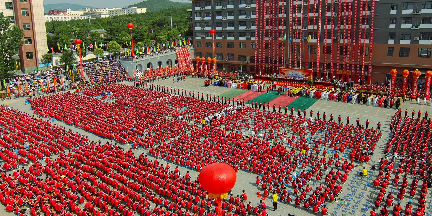 Students in red uniforms assemble in the academy courtyard.