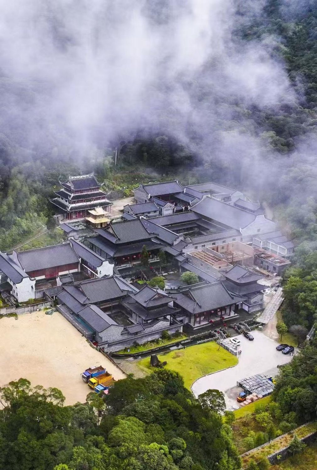 森林和流云间寺院建筑群的航拍。