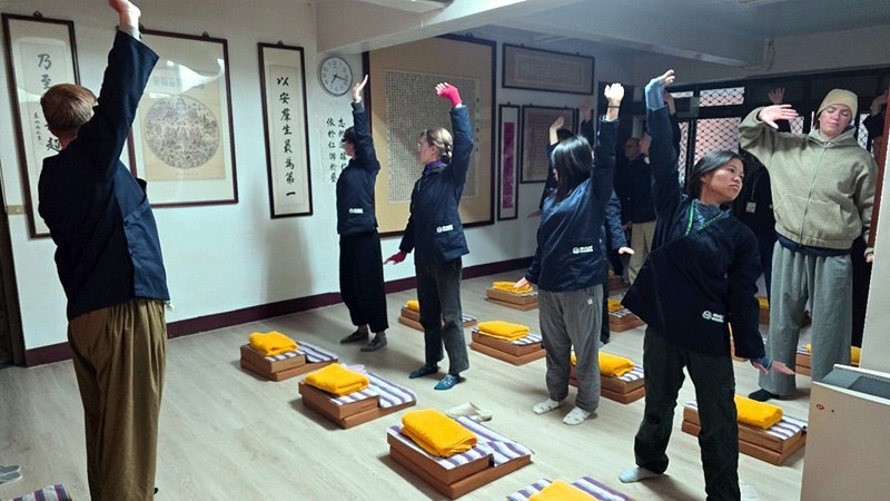 Farming Zen retreat participants stretch together in the practice hall.